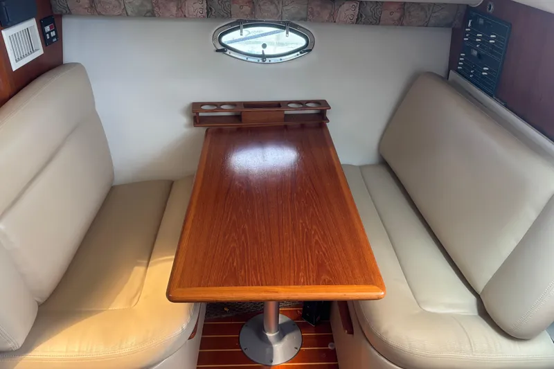 Slide: The Image of 1998 Tiara Yachts 2900 Coronet interior with wooden table and beige seating. - 19