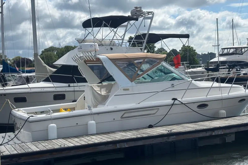 Slide: The Image of 1998 Tiara Yachts 2900 Coronet docked at marina under cloudy sky. - 2