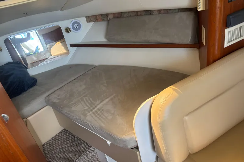 Slide: The Image of 1998 Tiara Yachts 2900 Coronet cabin interior with cushioned seating and window. - 22