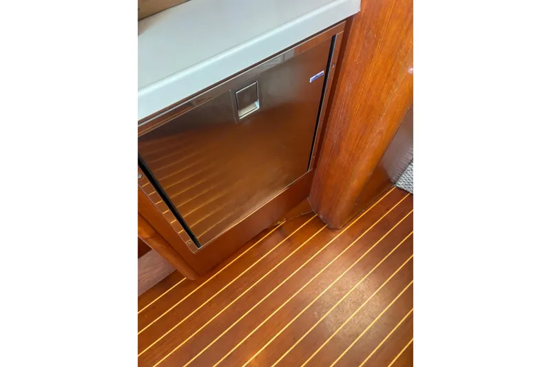 Slide: The Image of 1998 Tiara Yachts 2900 Coronet interior with wood flooring and compact fridge. - 25