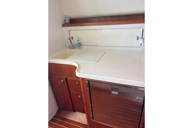 Slide: The Image of 1998 Tiara Yachts 2900 Coronet galley with sink, countertop, and storage cabinets. - 27