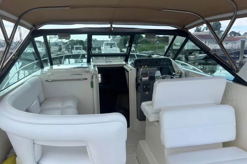 Slide: The Image of 1998 Tiara Yachts 2900 Coronet interior with white seating and helm, docked at marina. - 34
