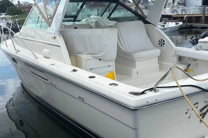 Slide: The Image of 1998 Tiara Yachts 2900 Coronet docked, showcasing sleek design and spacious seating area. - 7