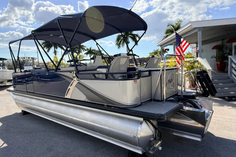 Slide: The Image of 2026 Avalon LSZ Rear Fish 24' pontoon boat with canopy, docked under sunny skies. - 10