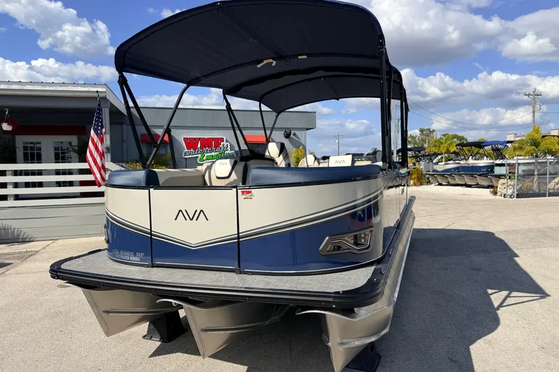 The Image of 2026 Avalon LSZ Rear Fish 24' pontoon boat at dealership, sunny day, American flag visible. - 2