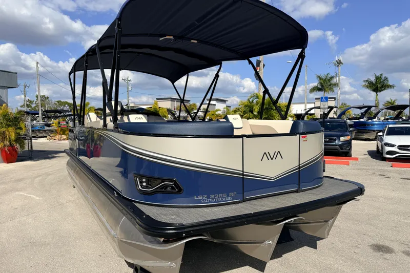 Slide: The Image of 2026 Avalon LSZ Rear Fish 24' pontoon boat with canopy, parked outdoors under blue sky. - 4