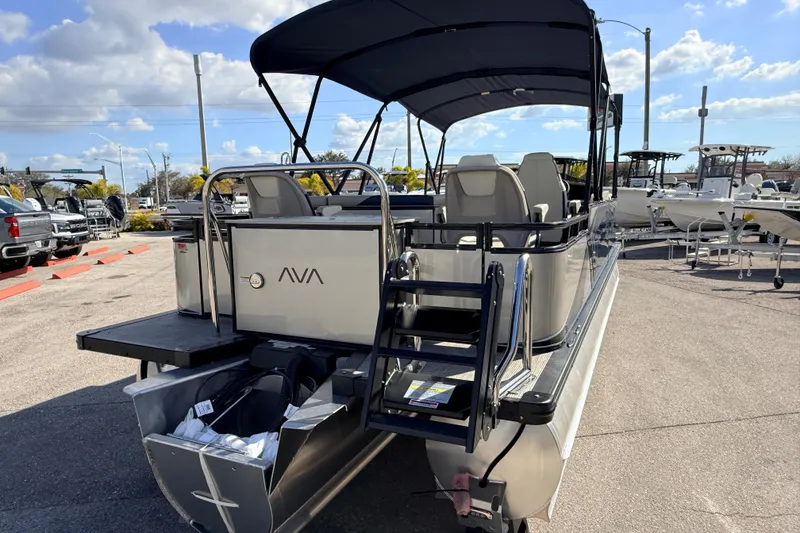 Slide: The Image of 2026 Avalon LSZ Rear Fish 24' pontoon boat with canopy, parked outdoors under blue sky. - 7