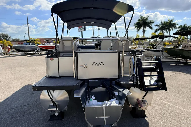 Slide: The Image of 2026 Avalon LSZ Rear Fish 24' pontoon boat with canopy, docked under a sunny sky. - 8