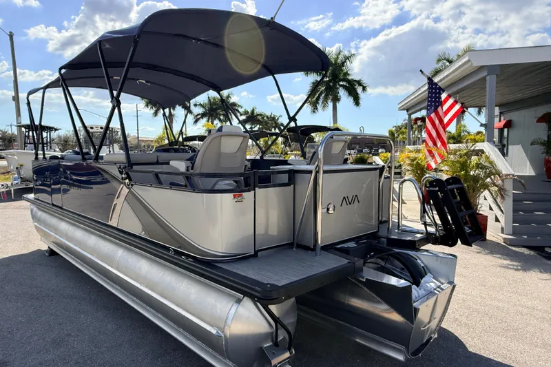 Slide: The Image of 2026 Avalon LSZ Rear Fish 24' pontoon boat with canopy, docked under sunny skies. - 9