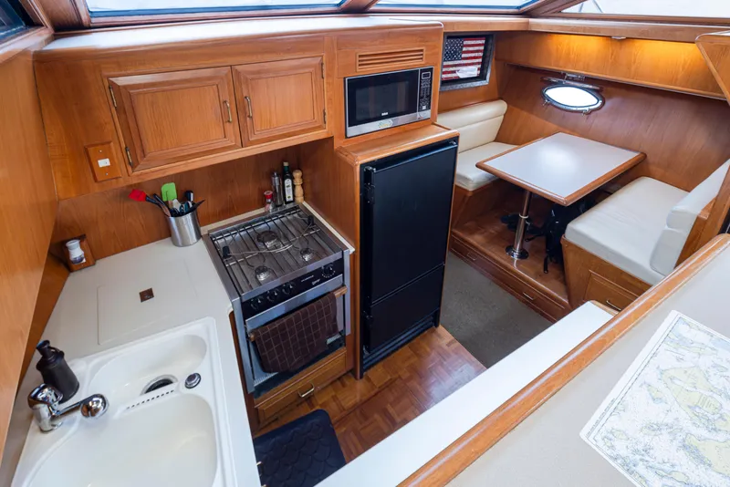 Slide: The Image of Interior of 1991 Ocean Alexander 440 Sundeck CPMY, featuring kitchen and dining area. - 26