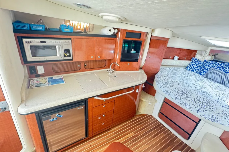 Slide: The Image of 2005 Sea Ray 340 Sundancer interior with kitchenette and cozy sleeping area. - 12