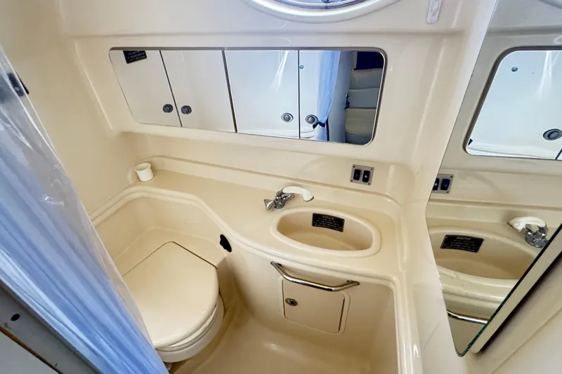 Slide: The Image of 2005 Sea Ray 340 Sundancer bathroom with sink, toilet, and mirrored cabinets. - 15