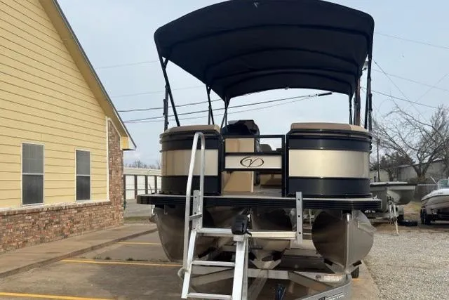 Slide: The Image of 2026 Veranda VR235F2 pontoon boat with canopy, parked near a building. - 2
