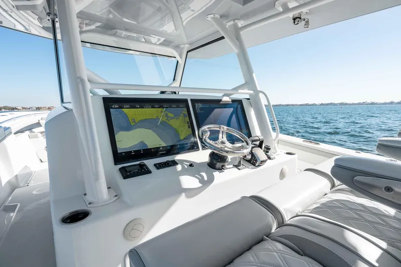 Slide: The Image of 2023 Yellowfin 42 Offshore boat dashboard with navigation screens and steering wheel. - 21