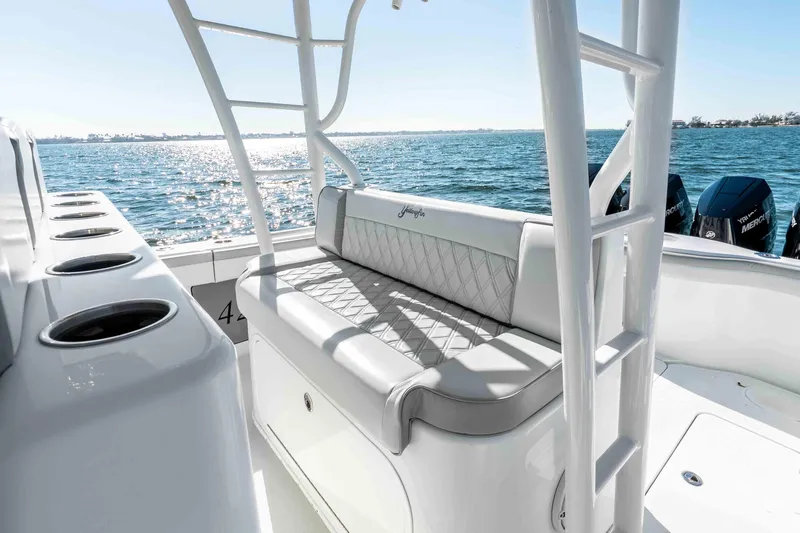 Slide: The Image of 2023 Yellowfin 42 Offshore boat interior with cushioned seating and ocean view. - 24