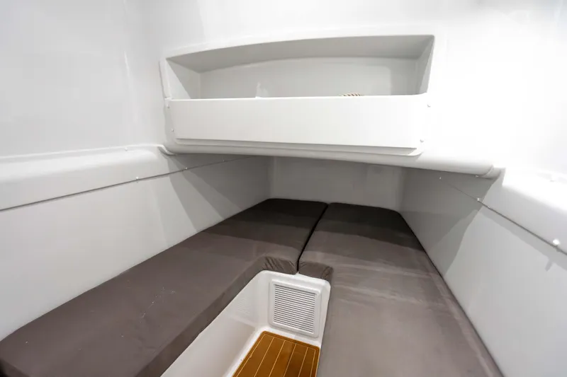 Slide: The Image of 2023 Yellowfin 42 Offshore cabin interior with cushioned seating and storage shelf. - 52
