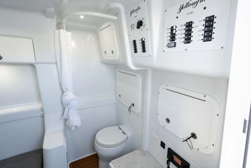 Slide: The Image of 2023 Yellowfin 42 Offshore boat interior with bathroom and control panels. - 53