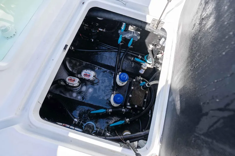Slide: The Image of 2023 Yellowfin 42 Offshore boat engine compartment with visible pumps and hoses. - 54