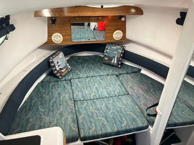 Slide: The Image of 2004 Pro-Line 30 WALK cabin interior with nautical-themed cushions and wooden accents. - 4
