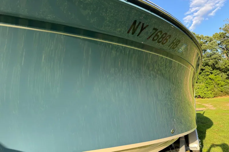 Slide: The Image of 2018 Grady-White Canyon 271 boat on trailer, sunny day, green surroundings. - 11