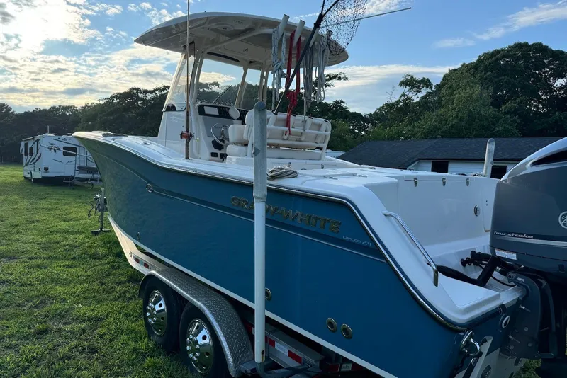 Slide: The Image of 2018 Grady-White Canyon 271 boat on trailer, parked on grass under a cloudy sky. - 8