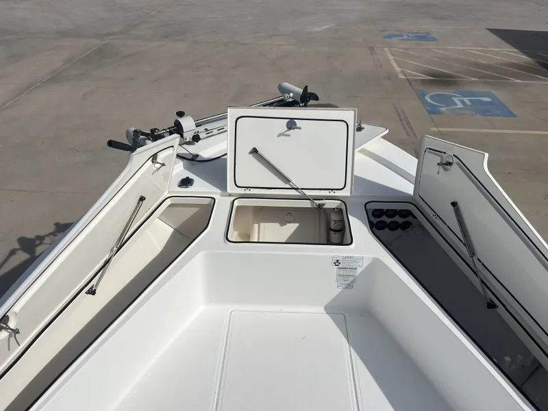 Slide: The Image of 2014 Mako 21 LTS boat with open storage compartments. - 13