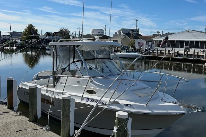 Slide: The Image of 2007 Polar 2300 Walkaround boat docked in a serene marina setting. - 1