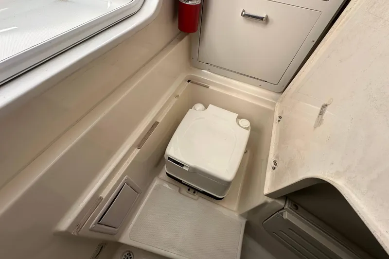 Slide: The Image of 2007 Polar 2300 Walkaround boat interior with portable toilet and storage compartment. - 13