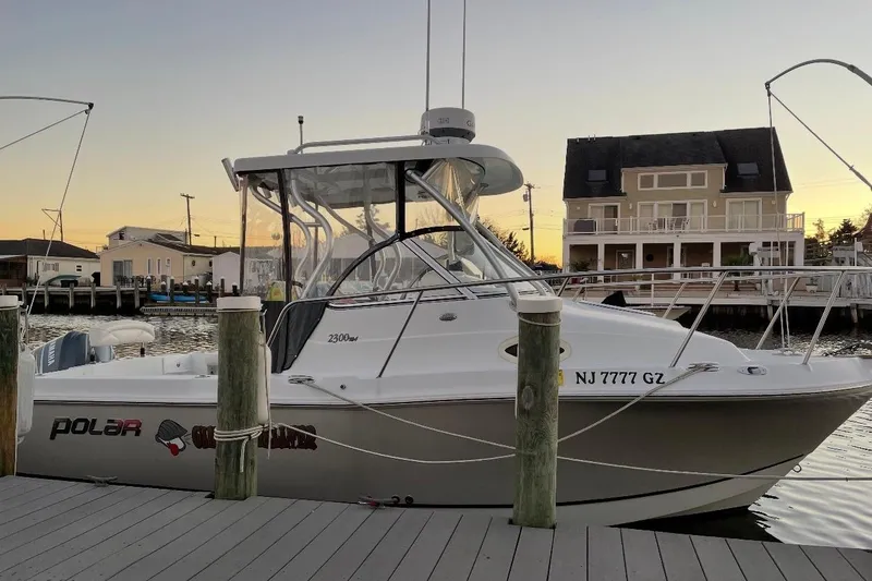 Slide: The Image of 2007 Polar 2300 Walkaround boat docked at sunset near waterfront homes. - 3
