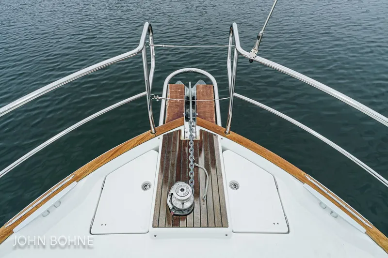 Slide: The Image of Bow view of 2018 Beneteau Swift Trawler 44, featuring anchor and railing over water. - 15