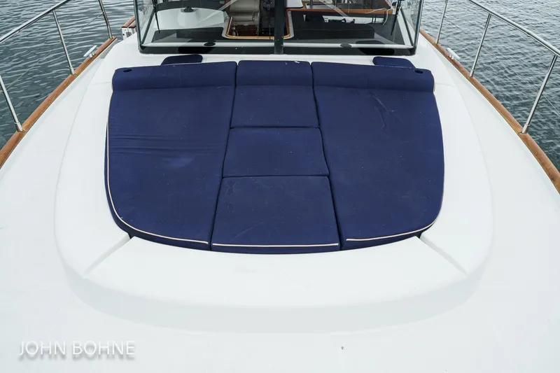 Slide: The Image of 2018 Beneteau Swift Trawler 44 with blue deck cushions on calm water. - 19