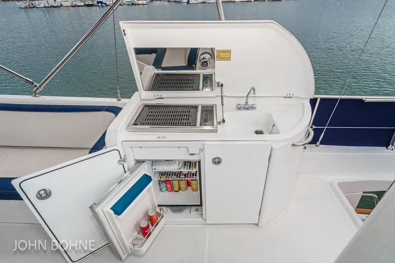 Slide: The Image of Outdoor kitchenette on 2018 Beneteau Swift Trawler 44 with grill, sink, and mini fridge. - 28