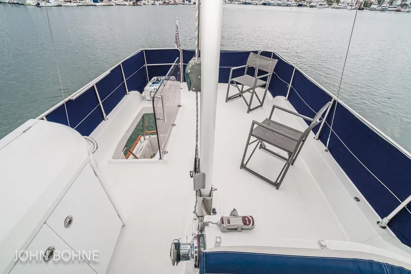 Slide: The Image of 2018 Beneteau Swift Trawler 44 flybridge with chairs, overlooking marina. - 29