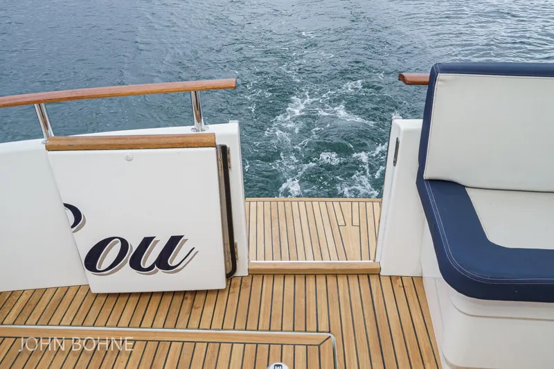Slide: The Image of 2018 Beneteau Swift Trawler 44 deck with wooden flooring and cushioned seating. - 36