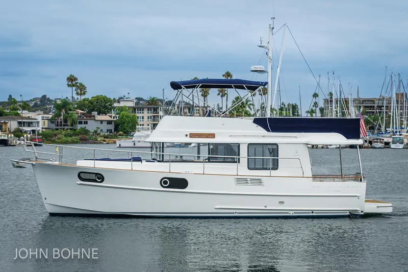 Slide: The Image of 2018 Beneteau Swift Trawler 44 on calm water, marina background. - 4