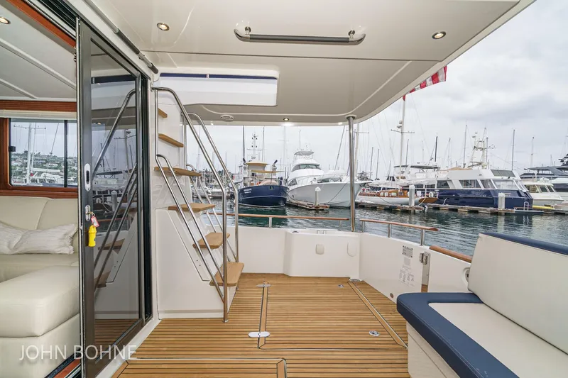 Slide: The Image of 2018 Beneteau Swift Trawler 44, spacious deck view at marina with seating and stairs. - 43