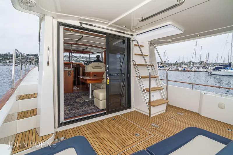 Slide: The Image of 2018 Beneteau Swift Trawler 44 yacht interior with wooden deck and marina view. - 46
