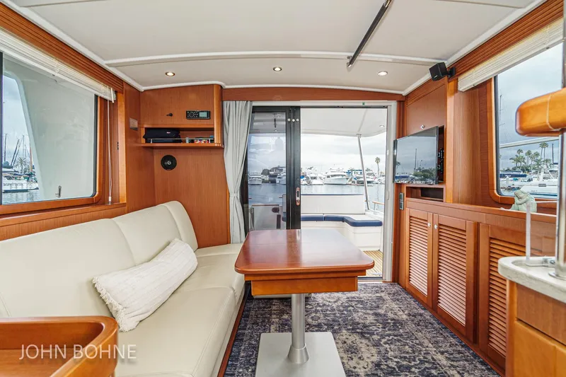 Slide: The Image of Interior of 2018 Beneteau Swift Trawler 44, featuring elegant wood finishes and marina view. - 48