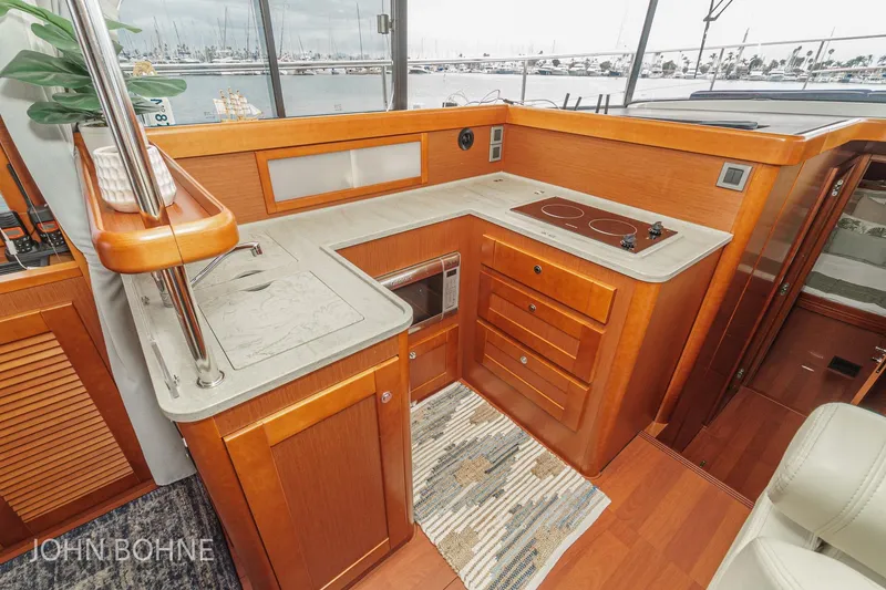 Slide: The Image of Luxurious 2018 Beneteau Swift Trawler 44 kitchen with modern amenities and elegant wood finish. - 60