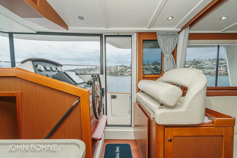Slide: The Image of Interior of 2018 Beneteau Swift Trawler 44, featuring helm and seating with ocean view. - 68