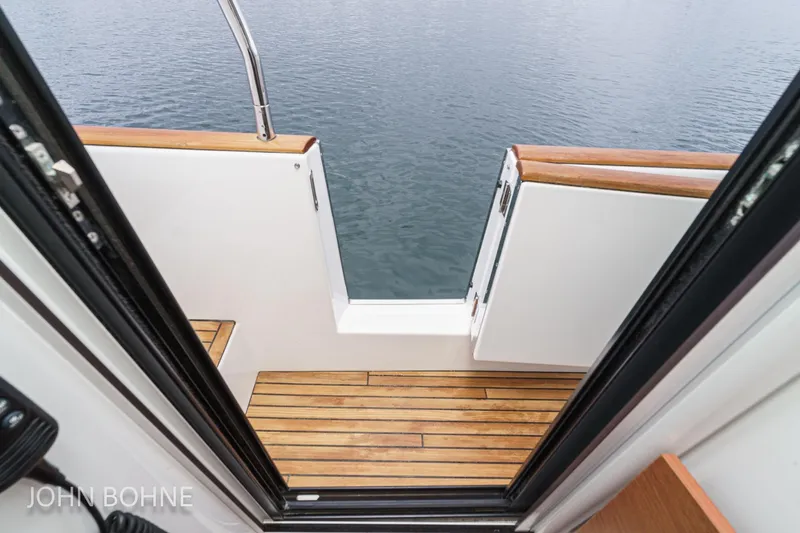 Slide: The Image of 2018 Beneteau Swift Trawler 44, open deck view with wooden flooring and water backdrop. - 69