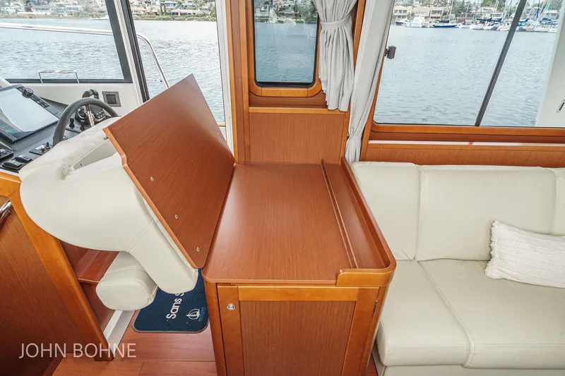 Slide: The Image of Interior of 2018 Beneteau Swift Trawler 44 with wooden table and white seating. - 79