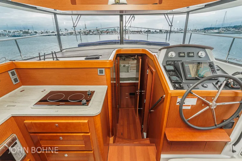Slide: The Image of 2018 Beneteau Swift Trawler 44 interior with helm, kitchen, and sea view. - 80