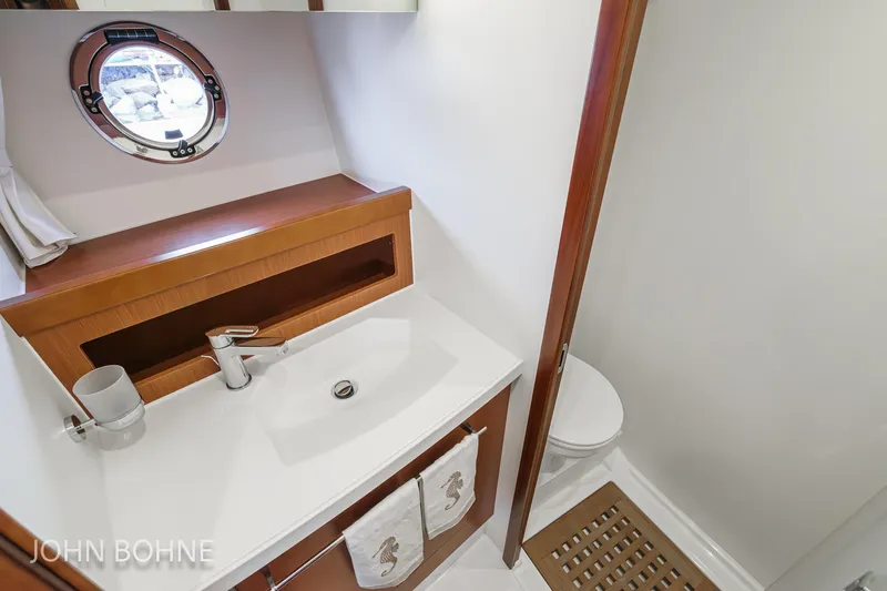Slide: The Image of Bathroom interior of 2018 Beneteau Swift Trawler 44 with sink and porthole window. - 85