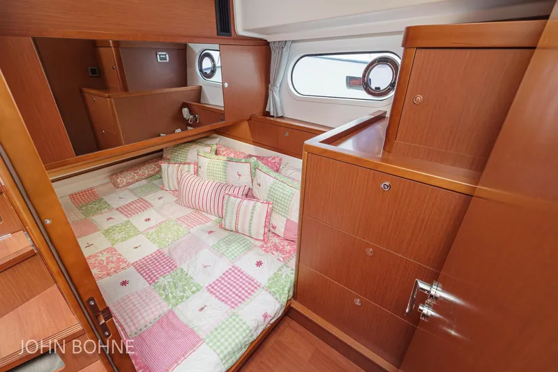 Slide: The Image of Cozy cabin interior of 2018 Beneteau Swift Trawler 44 with colorful bedding and wooden furnishings. - 87