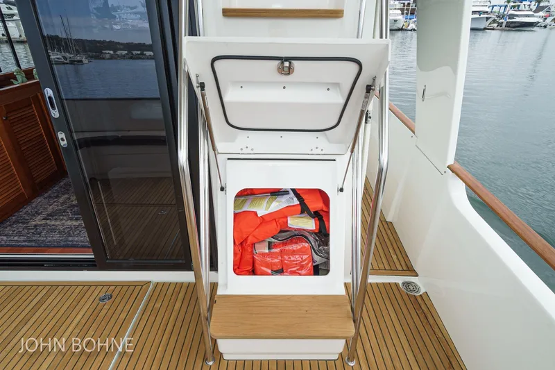 Slide: The Image of 2018 Beneteau Swift Trawler 44 with open storage compartment containing life jackets on deck. - 95