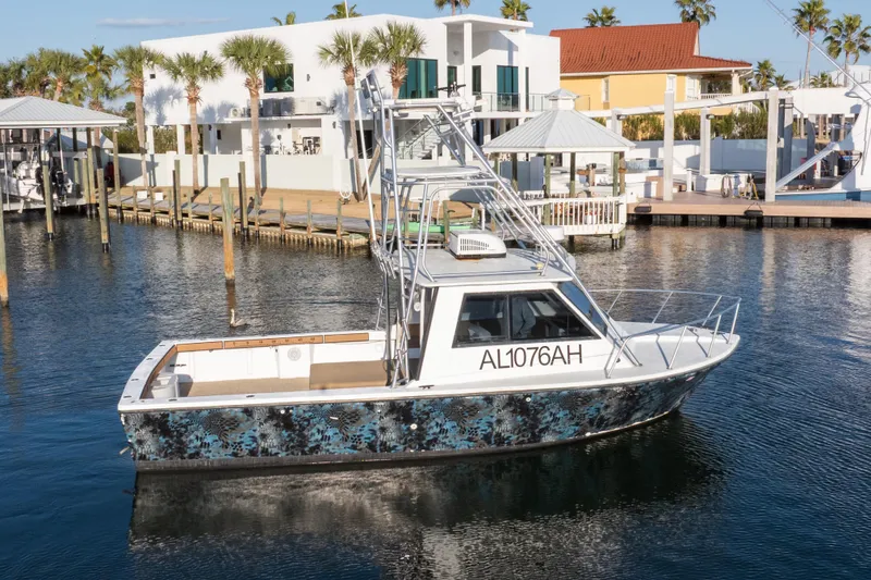 Slide: The Image of 2000 Island Hopper 30 boat docked in a scenic marina with palm trees. - 13
