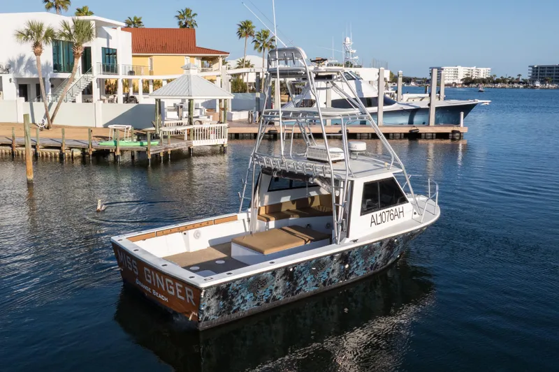 Slide: The Image of 2000 Island Hopper 30 boat docked in a marina with palm trees and waterfront homes. - 14