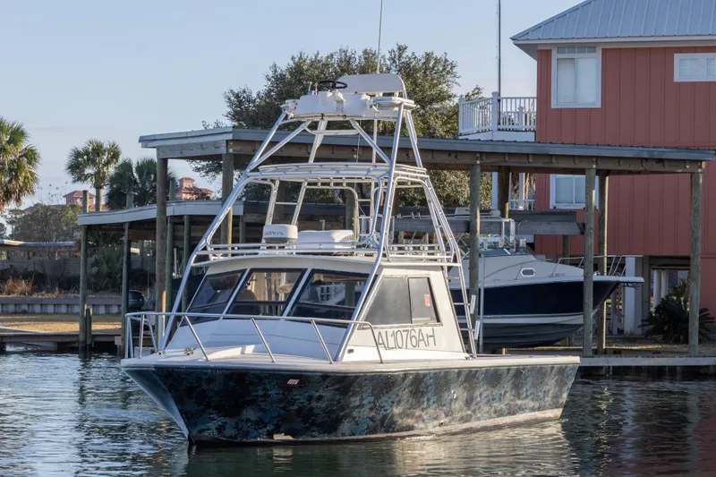 Slide: The Image of 2000 Island Hopper 30 boat docked near palm trees and waterfront buildings. - 2