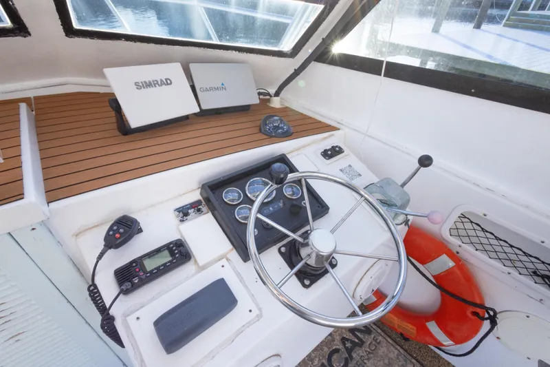Slide: The Image of Helm of 2000 Island Hopper 30 with navigation equipment and life preserver. - 23